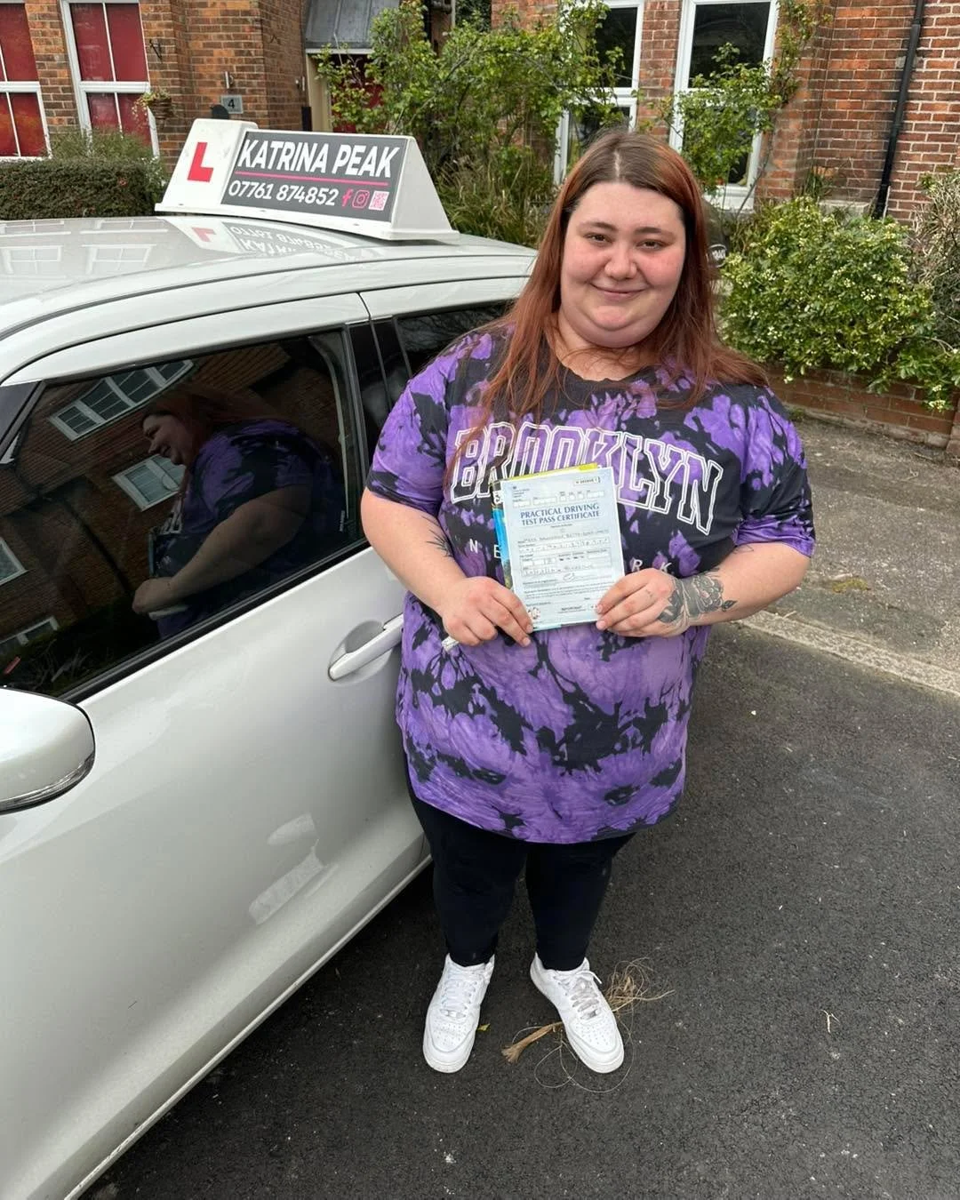 A pupil celebrating with their driving test pass certificate