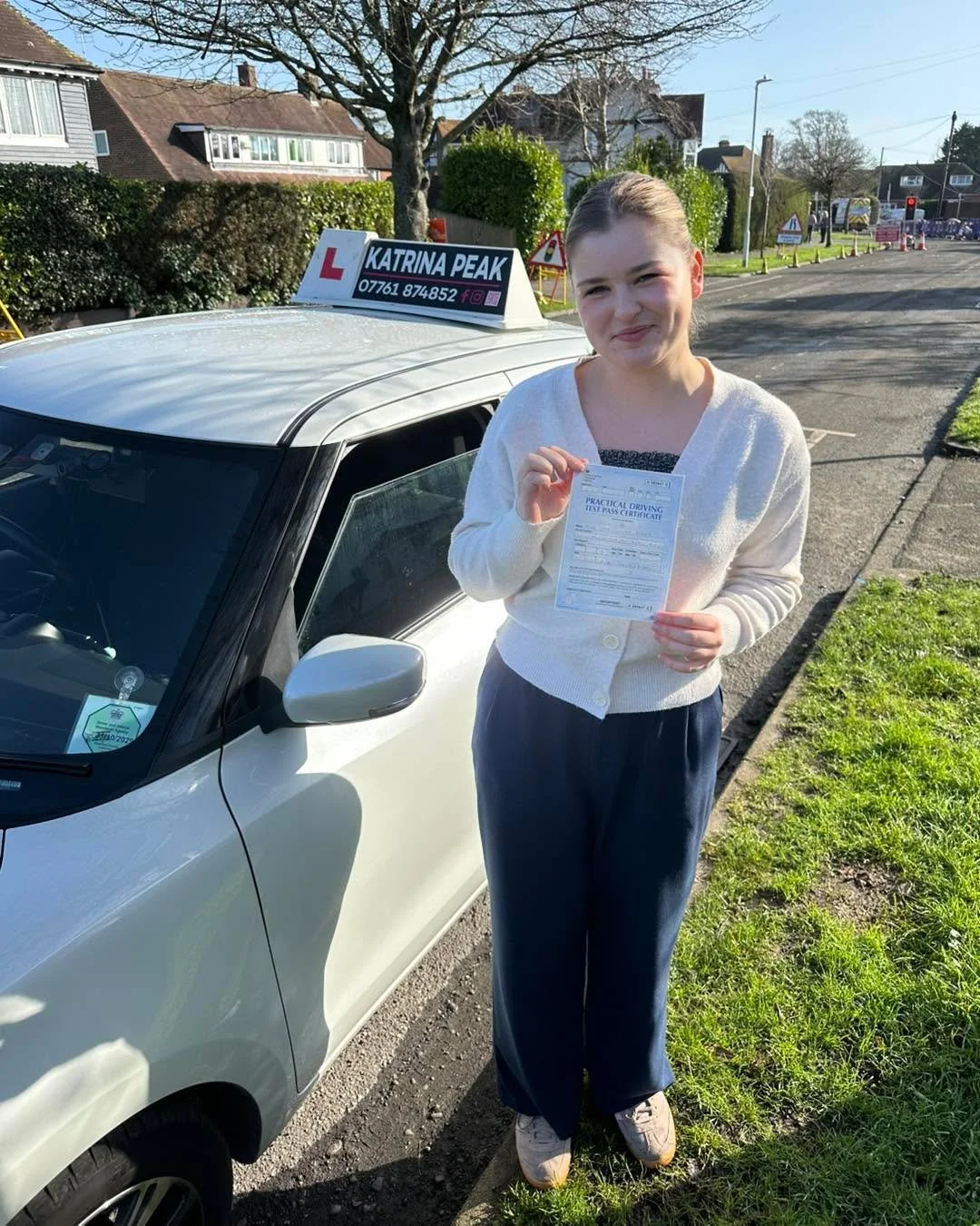 A pupil with their pass certificate on a sunny street in Folkestone