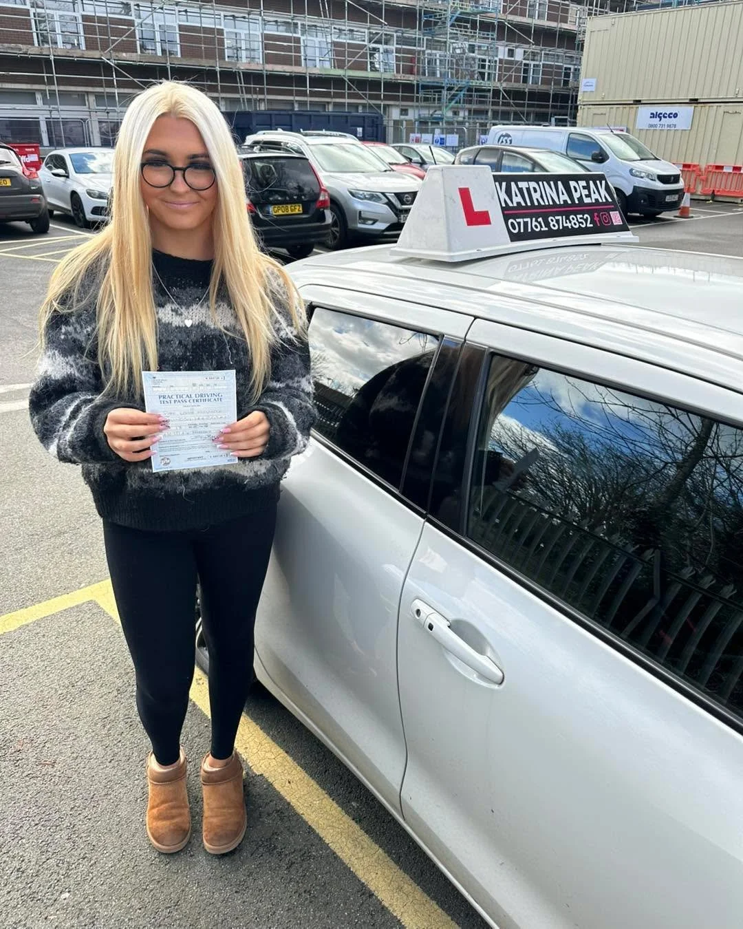 A newly qualified driver holding their test pass certificate